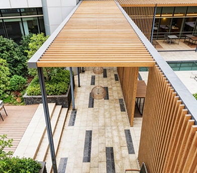 Modern covered patio corridor with wood slat roof in Los Angeles by Patio Chic LA